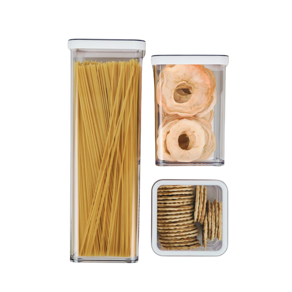 Drei durchsichtige Behälter mit Spaghetti, Apfelringen und Crackern, auf weißem Hintergrund.