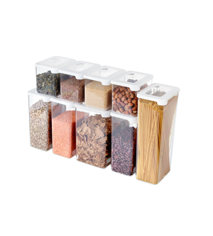 Neun klare, rechteckige Orthex SmartStore Vorratsdosen KLAR - Weiss, jeweils gefüllt mit trockenen Lebensmitteln wie Samen, Körnern und Spaghetti. Diese luftdichten, stapelbaren Behälter sind ordentlich in drei Reihen für eine organisierte Aufbewahrung angeordnet.