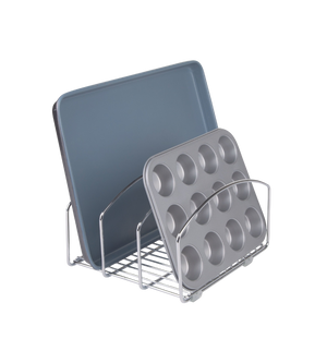 Der iDesign CLASSICO - Backblech-Organizer METALL aus Edelstahl hält ein graues Backblech und eine Muffinform vertikal für ordentliche Aufbewahrung, während der schlichte Hintergrund den funktionalen Organizer betont.