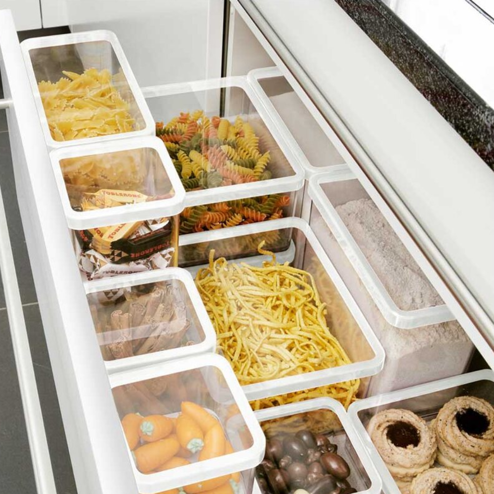 Kitchen drawer with storage containers for pasta and sweets, white frames, dark countertop, text "TORRONI."