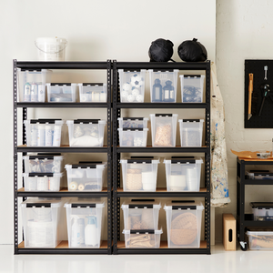 Auf den Metallregalen stehen Orthex SmartStore Box KLAR 40x30x11cm (7,5L), BPA-frei und ordentlich organisiert mit Bastelmaterial. In der Nähe befinden sich eine Arbeitsschürze, eine Stecktafel mit Werkzeugen und ein Rollwagen mit weiteren Materialien.