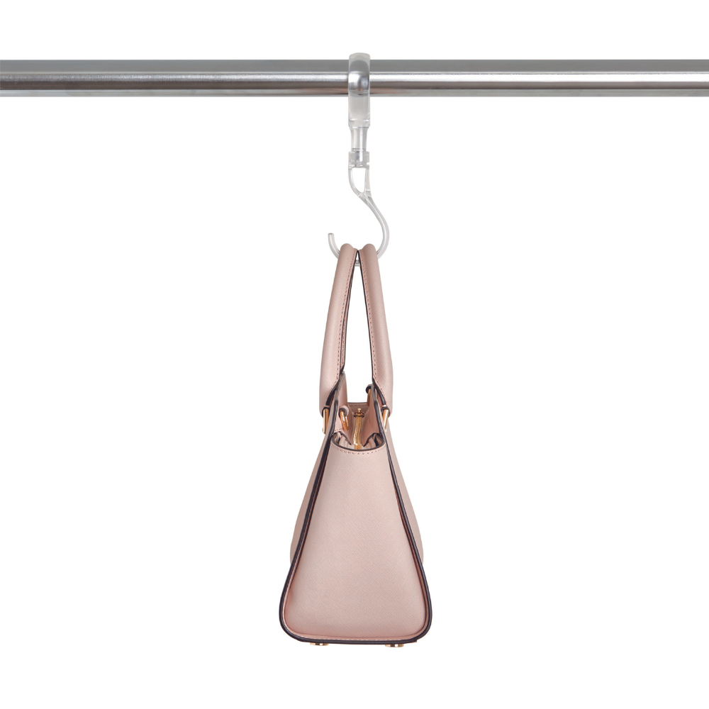 Am iDesign HOME EDIT - S-Haken KLAR hängt eine beigefarbene Handtasche an einer Metallstange vor weißem Hintergrund - ideal für platzsparende Kleiderschrank Ordnung.