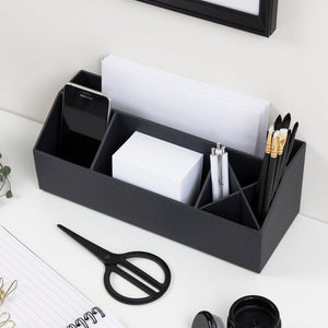 Schreibtisch-Organizer hält Smartphone, Papier, Stifte und Schere in Büro-Umgebung.